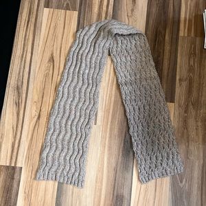 Tan knit scarf with ripple pattern.